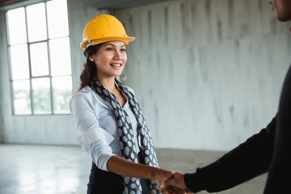 Businesswoman with hardhat shaking hand — Stock Photo, Image