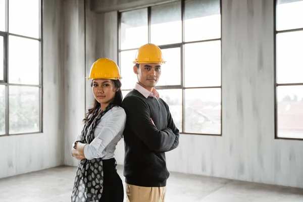 Equipo de negocios espalda con espalda cruzaron su brazo y vistiendo hardhat — Foto de Stock