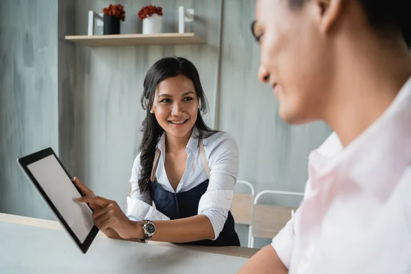 Camarera femenina ofreciendo el nuevo menú al cliente — Foto de Stock