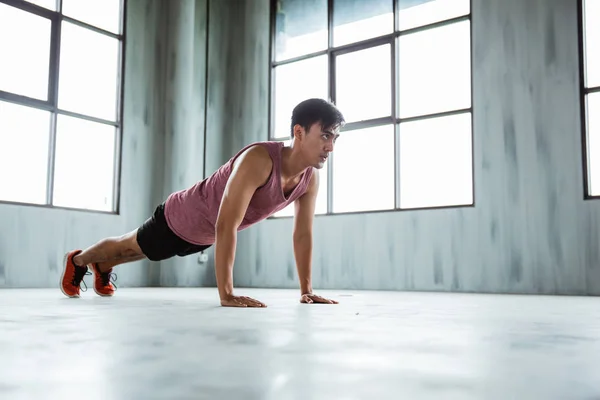 Fitness man doet push ups in sportschool binnen — Stockfoto