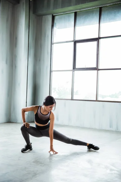 Mulher no ginásio fazendo exercícios de alongamento — Fotografia de Stock