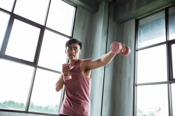 Homem de perfuração e segurando dumbell — Fotografia de Stock