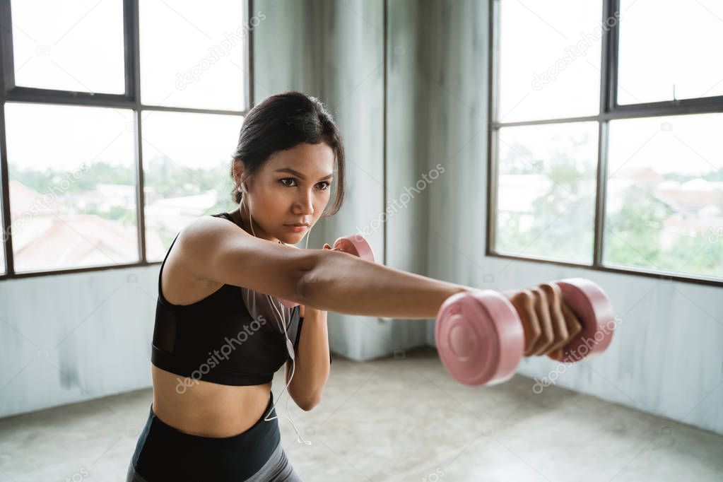woman using dumbbell doing some boxing exercise