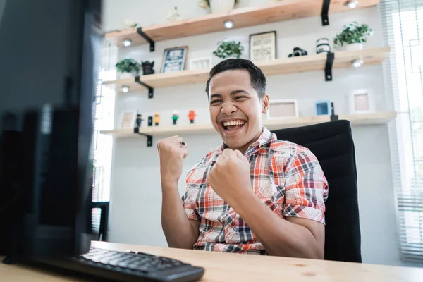 Jovem asiático animado enquanto trabalhava no escritório — Fotografia de Stock