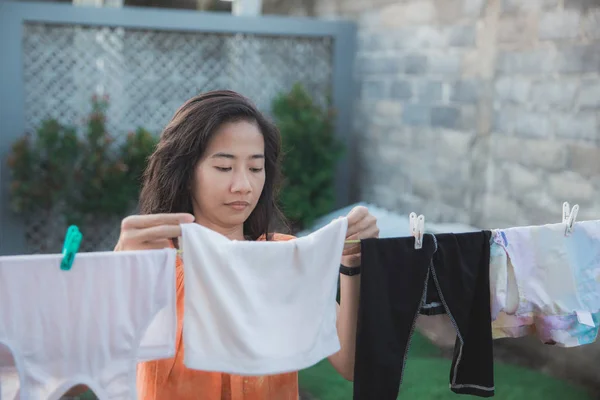 Retrato de uma dona de casa secando roupas de manhã — Fotografia de Stock