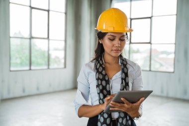 Dijital tablet işçisi tutun giyen kadın mühendis