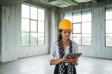 Dijital tablet işçisi tutun giyen kadın mühendis