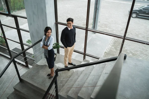 Geschäftsleute lächeln mit gefalteten Händen auf der Treppe stehend — Stockfoto