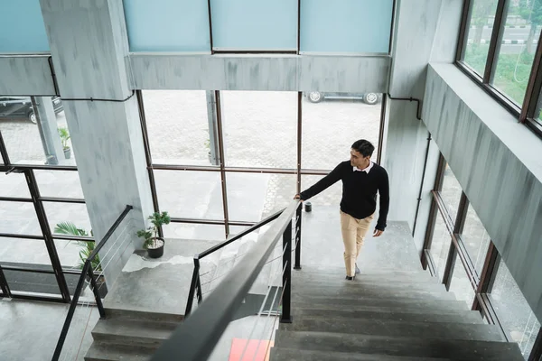 asian businessman walking up on the stairs go to his room in the upstairs