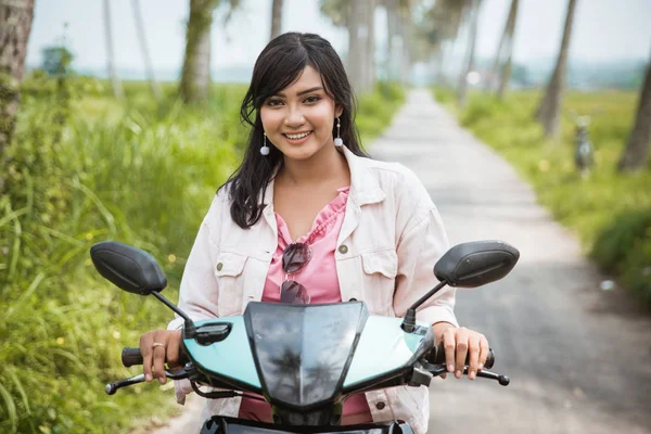 Asiatico donna godere equitazione il suo moto in tropicale campagna strada — Foto Stock