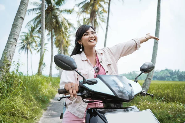 Woman raised her arm while ride her scooter — Stock Photo, Image