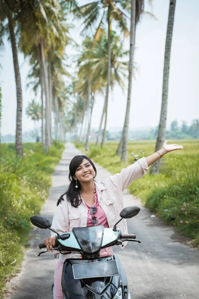 Азіатська жінка насолоджується їздою на мотоциклі в тропічній сільській дорозі — стокове фото