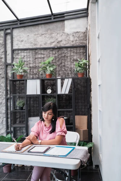 Kvinnliga arbetstagare i hennes kontor som arbetar på pappersarbete — Stockfoto