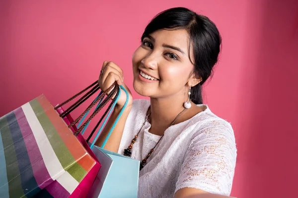 Женщина с сумками для покупок делает селфи — стоковое фото