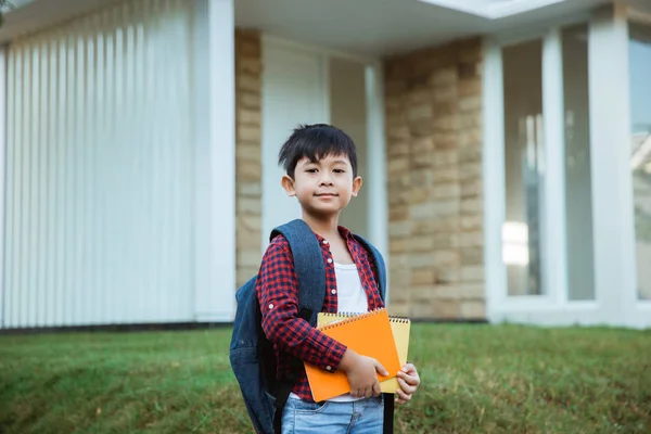 Estudante elementar na frente de sua casa sorrindo com mochila — Fotografia de Stock
