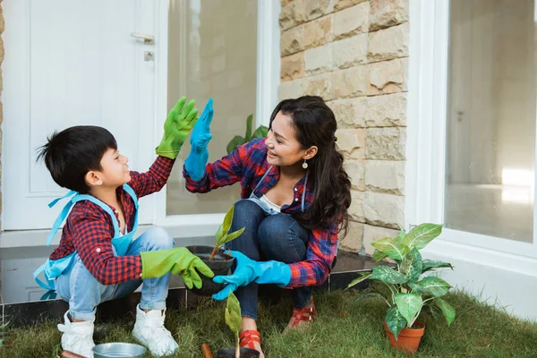 Mère et fils highfive tout en jardinant ensemble à la maison — Photo