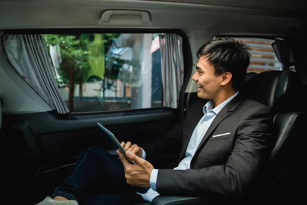 Businessman with tablet sitting on passenger seat — Stock Photo, Image