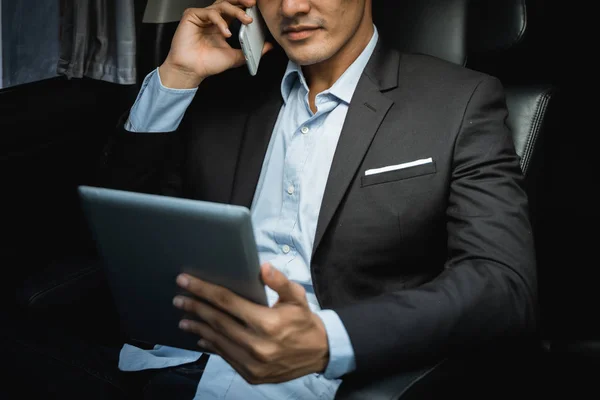 Podnikatel, volání po telefonu a tabletu v autě — Stock fotografie