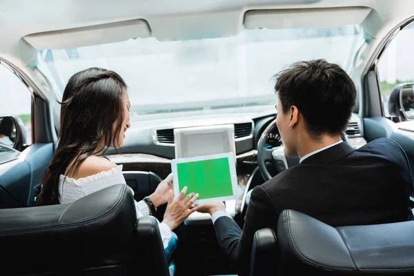 Two couple using tablet together while driving a car — Stock Photo, Image