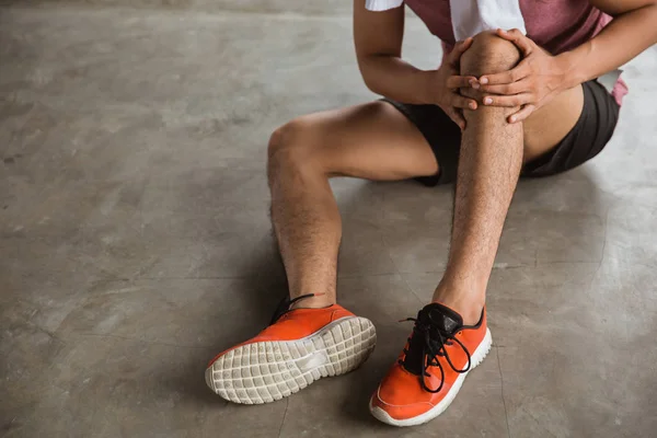 Mano masculina sosteniendo lesión de rodilla —  Fotos de Stock