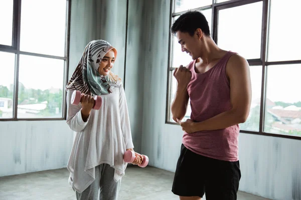 Женщина хиджаб делать упражнения веса с помощью личного тренера — стоковое фото