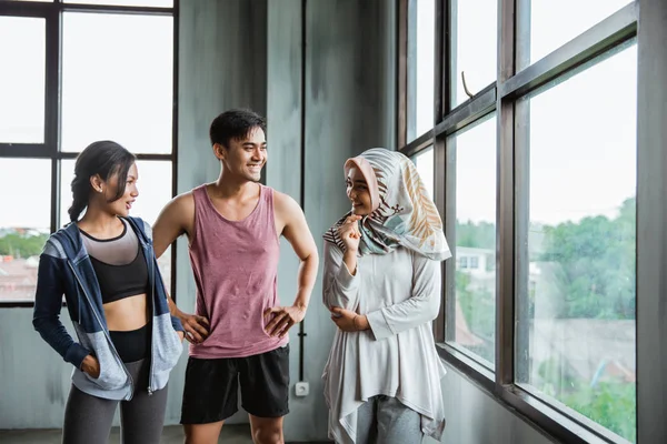 Amigos sonrientes después de hacer ejercicio en el gimnasio hablando —  Fotos de Stock