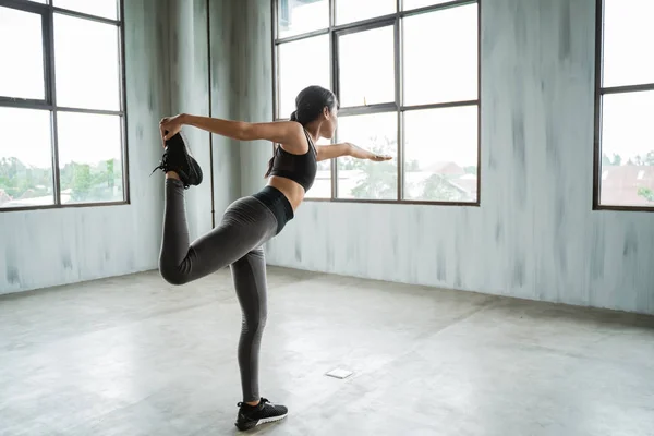 Активна жінка робить рух рівноваги для розтягування ніг — стокове фото