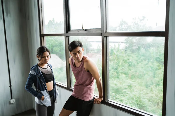 Homem desportivo e mulher de pé uns contra os outros — Fotografia de Stock