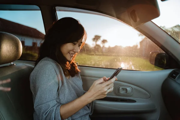 Woman using mobile phone while in car — Stock Photo, Image