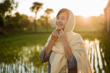 Asyalı kadın deneyin onun başörtüsü düzeltmek için