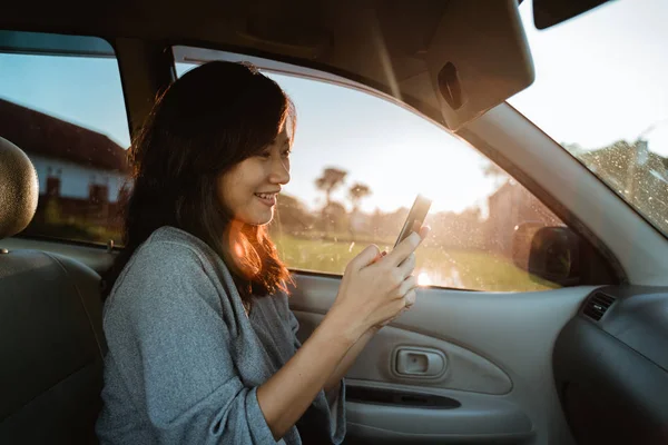 Mulher usando telefone celular enquanto no carro — Fotografia de Stock