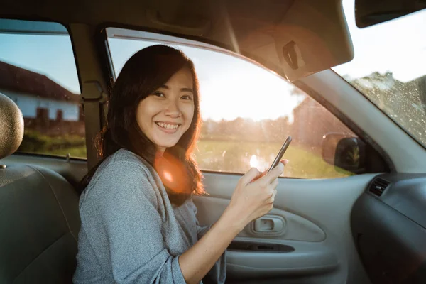 Woman using mobile phone while in car — Stock Photo, Image