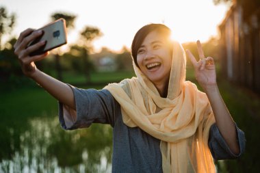 Asya Müslüman kadını kabul selfie ile hareket eden telefon