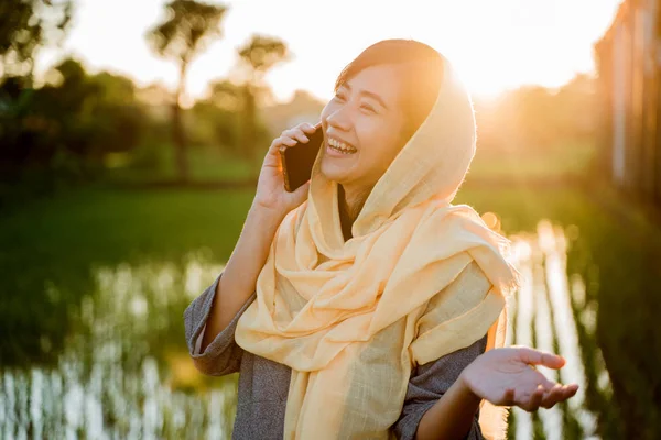 Мусульманка со смартфоном на открытом воздухе — стоковое фото