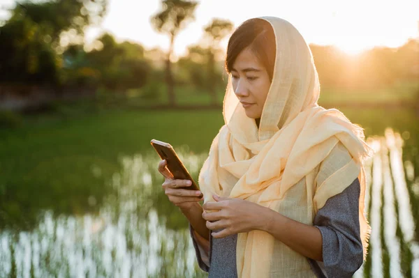 Mulher muçulmana com hijab usando telefone celular — Fotografia de Stock