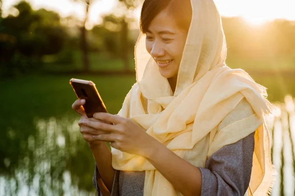 Mulher muçulmana com hijab usando telefone celular — Fotografia de Stock