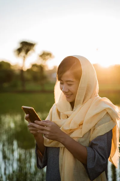 Mulher muçulmana com smartphone ao ar livre — Fotografia de Stock