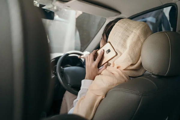 Женщина за рулем автомобиля во время телефонного звонка — стоковое фото