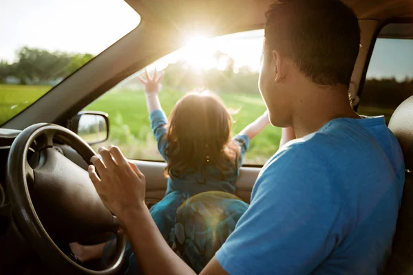 dad and daughter enjoy sunset inside car