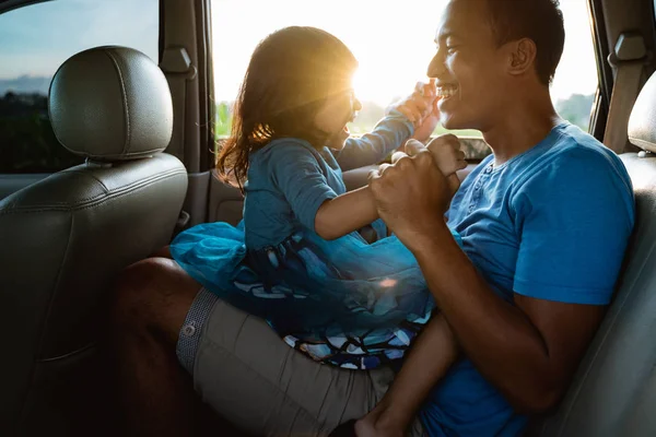 Papi cosquillas su pequeña niña en el coche — Foto de Stock