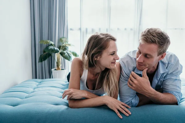 ロマンチックなカップルは、ベッドの上に横たわっている間チャットを楽しみます — ストック写真
