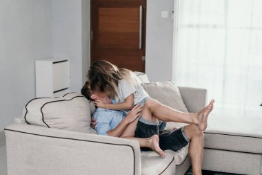 Sevgi çift oturma ve sarılmak kanepede