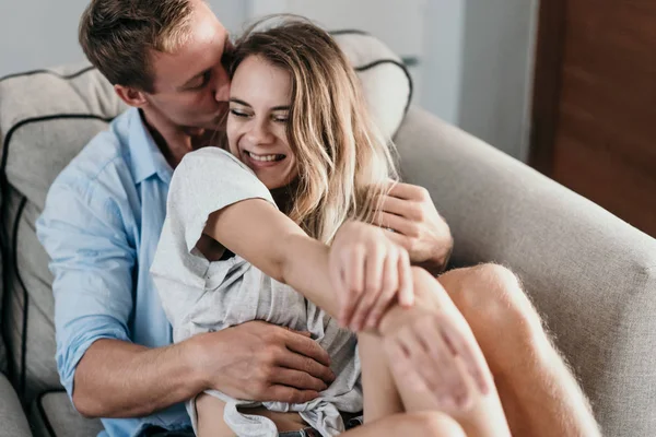 Affectionate couple sitting and hug on couch — Stock Photo, Image