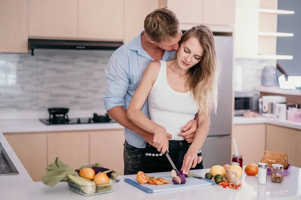 Νεαρό ρομαντικό ζευγάρι στη σύγχρονη κουζίνα μαγειρεύοντας μαζί — Φωτογραφία Αρχείου
