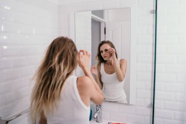 Genç kadın yüz yaş başlar görmek için yansıtılmış