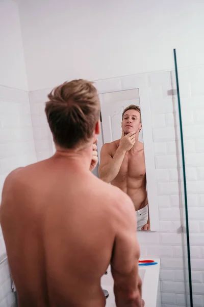 Attractive muscular man preparing himself in front of mirror — Stock Photo, Image