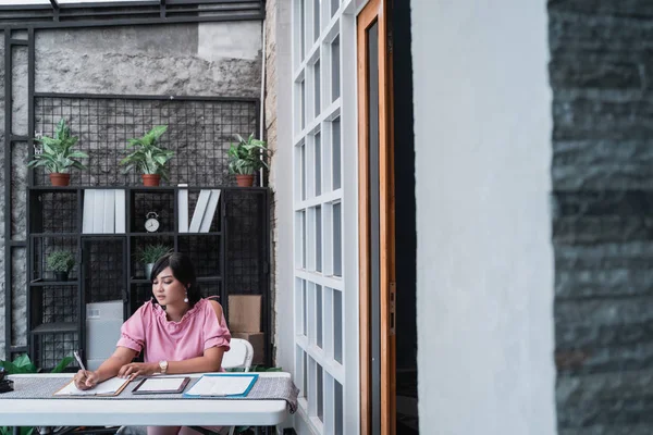 Kvinnliga arbetstagare i hennes kontor som arbetar på pappersarbete — Stockfoto