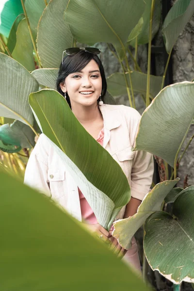 Asiatico donna tra tropicale verde foglie in estate — Foto Stock
