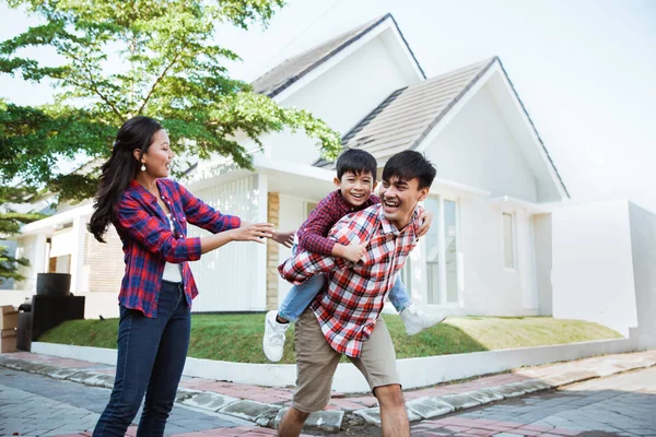 Förälder med barn njuta spelar tillsammans framför sin nya hus — Stockfoto
