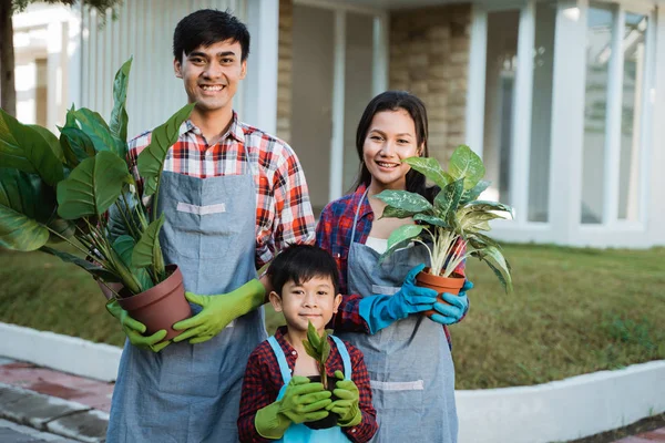 Vader moeder en zoon tuinieren activiteit samen thuis tuin — Stockfoto